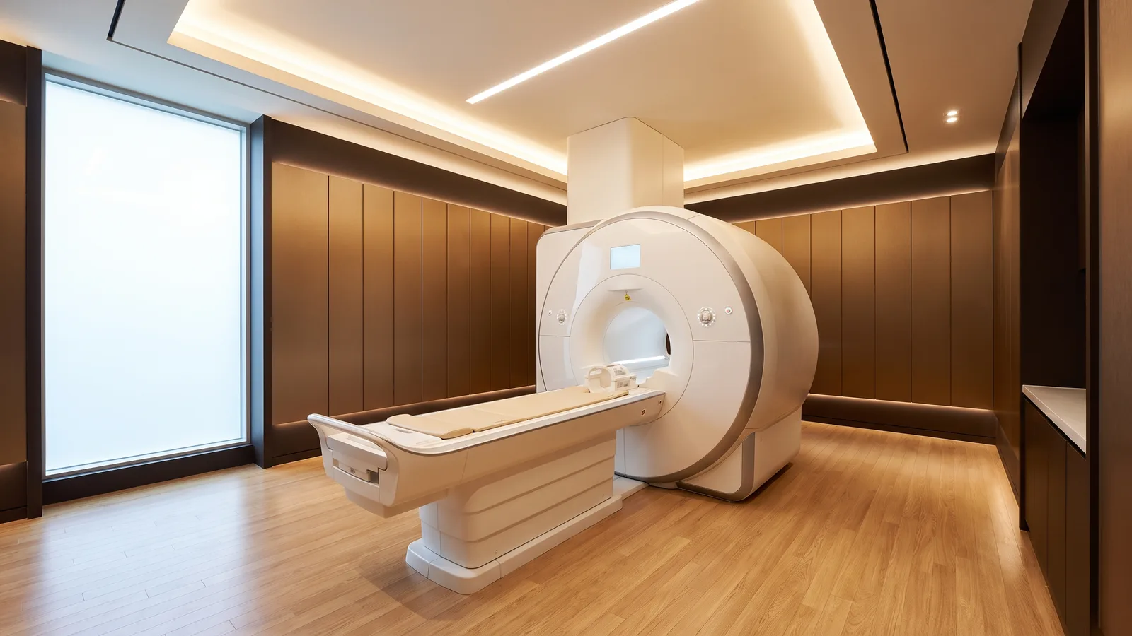 따뜻한 브라운 벽면과 조명이 있는 밝고 빈 MRI 검사실의 원통형 장비와 검사대