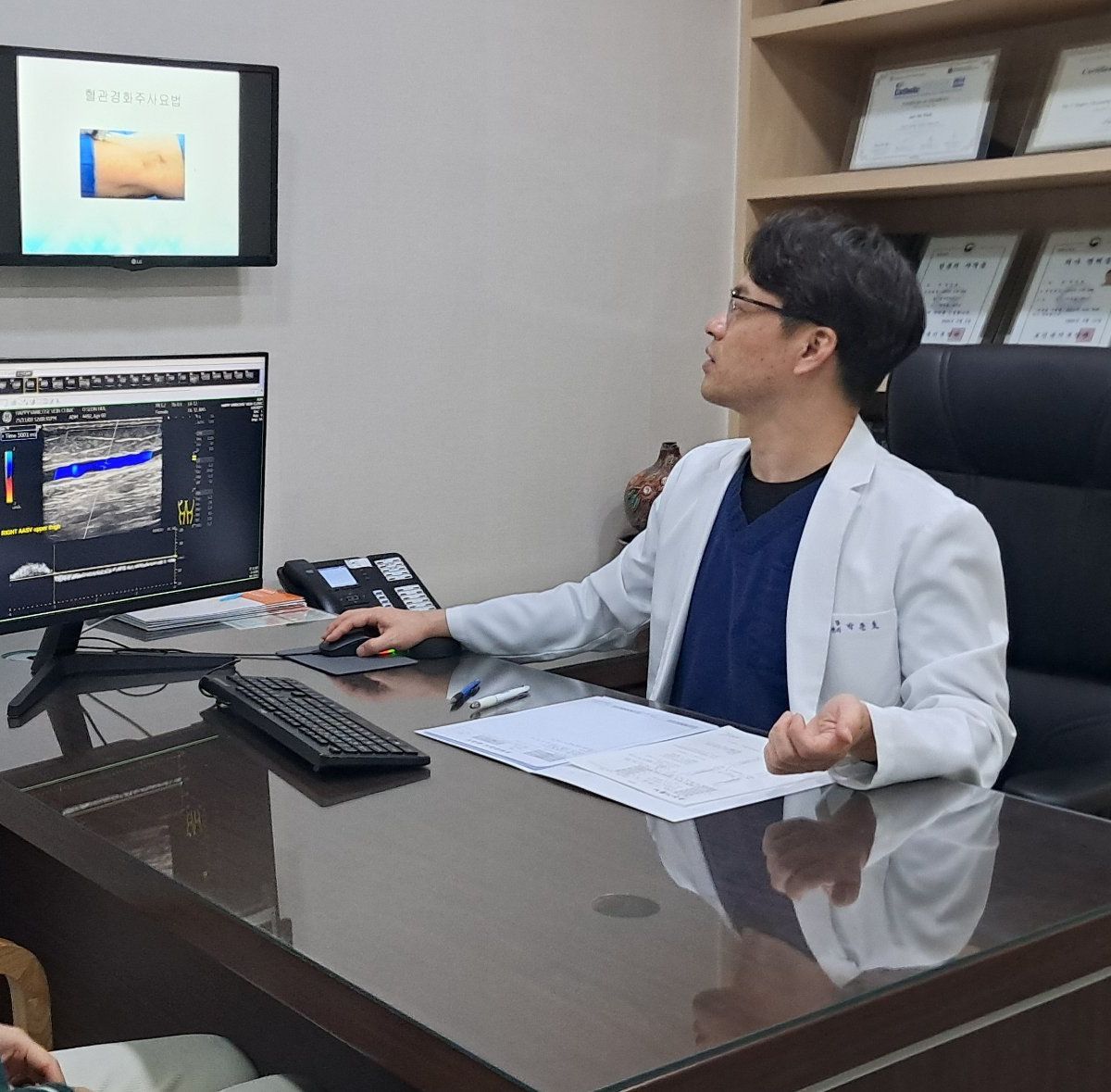박준호 대표원장이 진료실 책상에서 환자와 마주 앉아 상담하는 모습